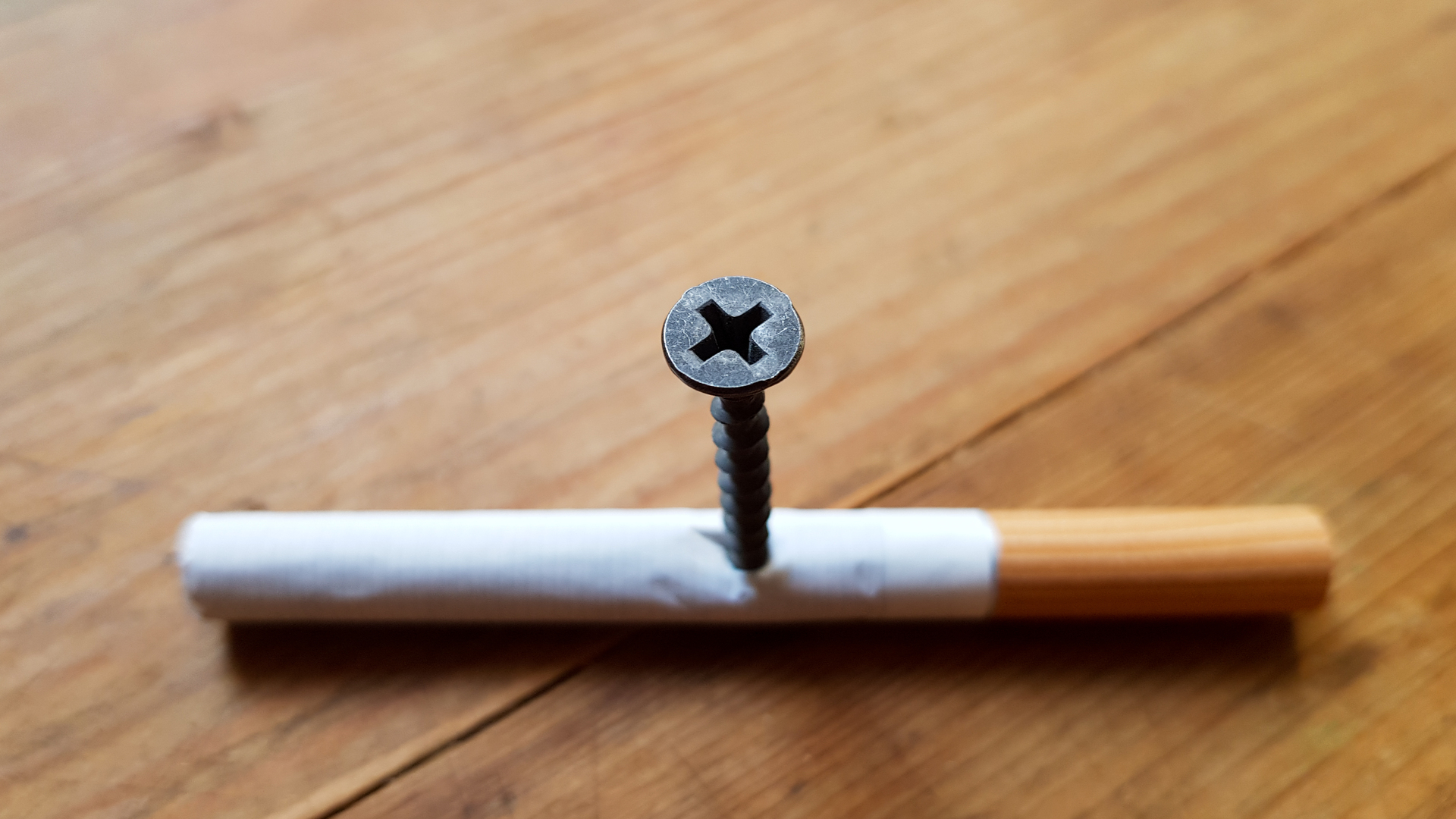 1920 screw and yellow background screw screwed into a cigarette anti smoking concept